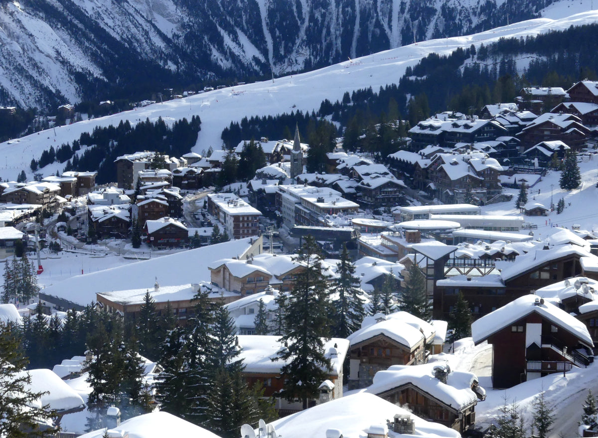 Snow covered chalets and ski slopes at sunrise in Courchevel 1850, the mountain village where Cheval Blanc Courchevel sits