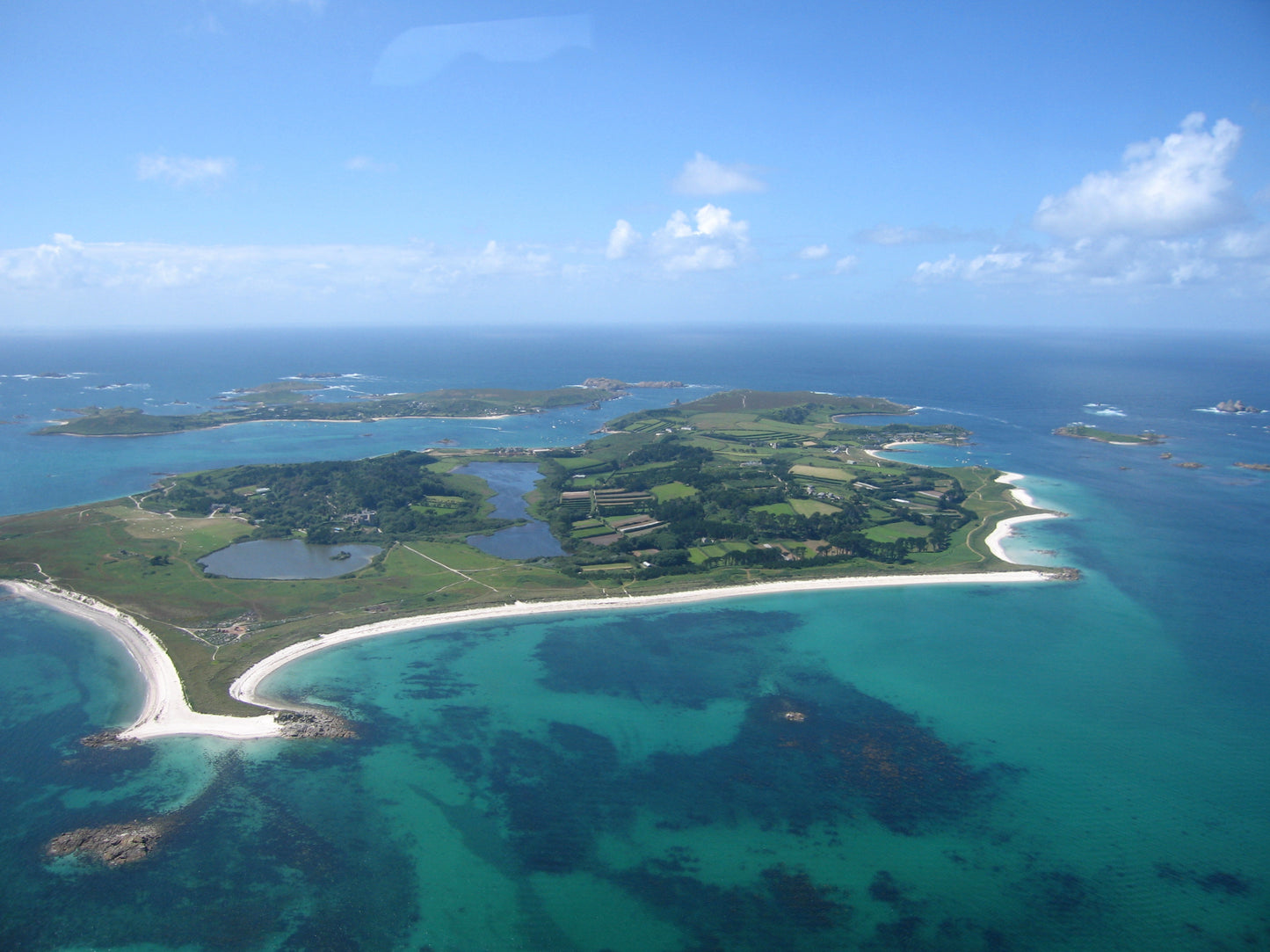 Aerial view of Tresco, the Isles of Scilly island where the spa is set, showing its turquoise water and white sand beaches.