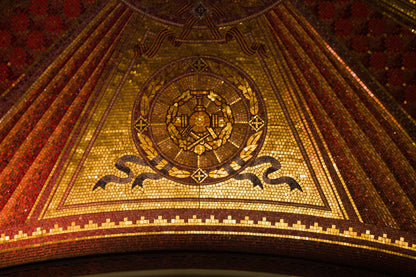 Gold mosaic tesserae catching low light, the gilded oval reception that opens the spa