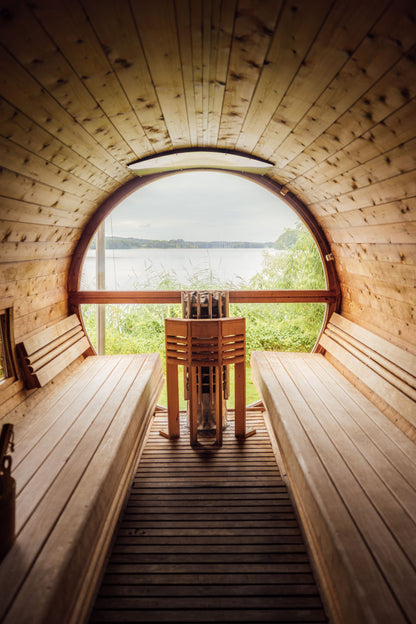 Round window barrel sauna overlooking a calm alpine lake at Hôtel Royal, Évian Resort