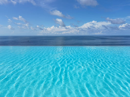 Turquoise infinity pool meeting open sea at the horizon