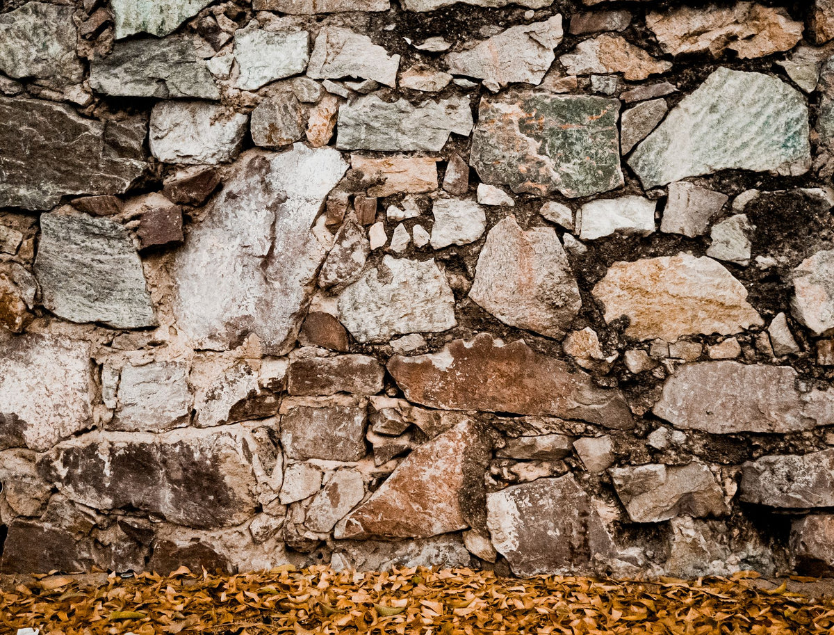 Close view of old weathered stone wall in warm tones, evoking the restored twelfth century abbey stables that house the spa