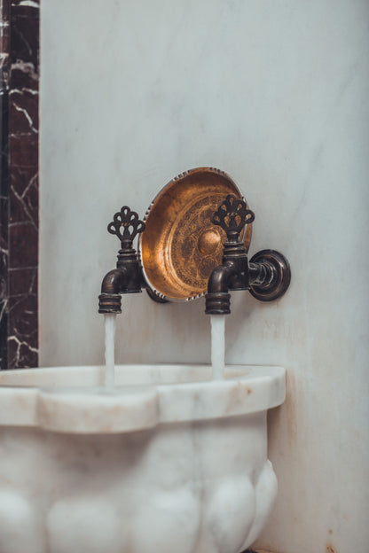 A brass tap pours water into a marble basin, an evocative image for the Turkish style hammam at The Spa at The Newt in Somerset