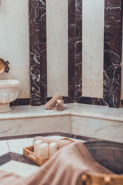 A marble steam room interior with a folded towel and candle, Ritz Paris Club & Spa.
