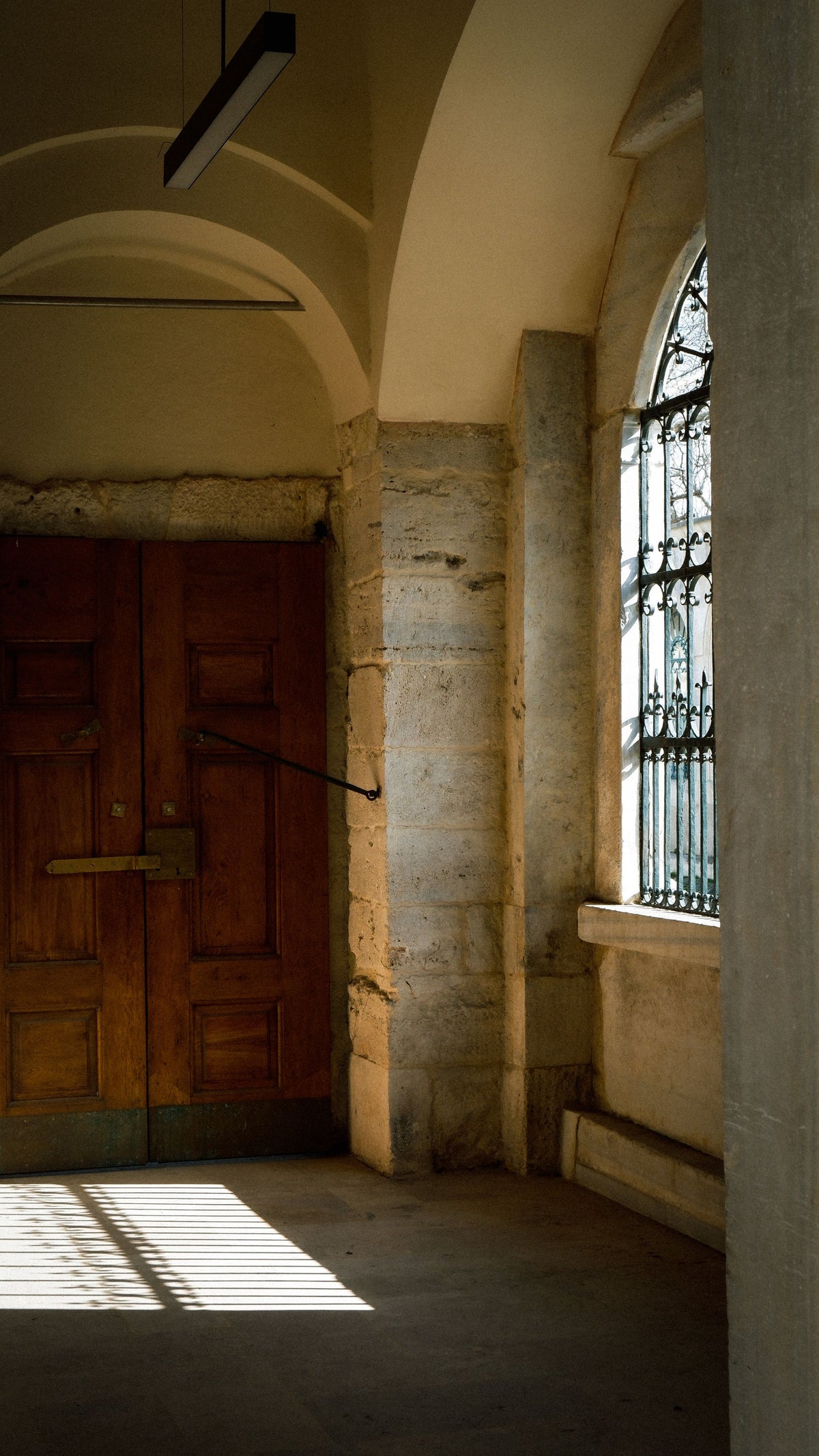 An old arched wooden door framed in weathered stone