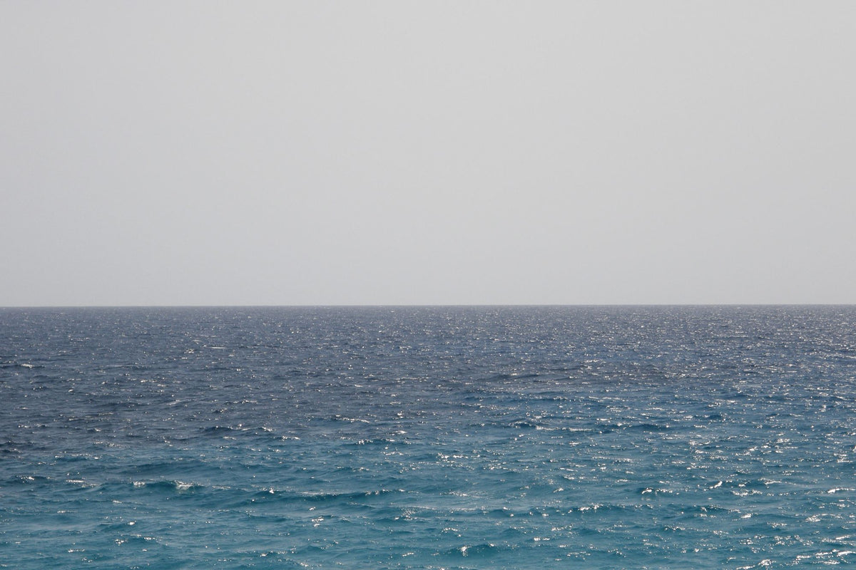 Calm grey green Mediterranean sea under soft morning light, evoking the view from a longevity clinic above the Costa Blanca
