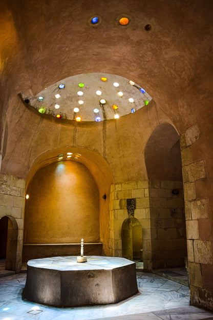 Domed hammam ceiling set with coloured glass portholes casting warm light