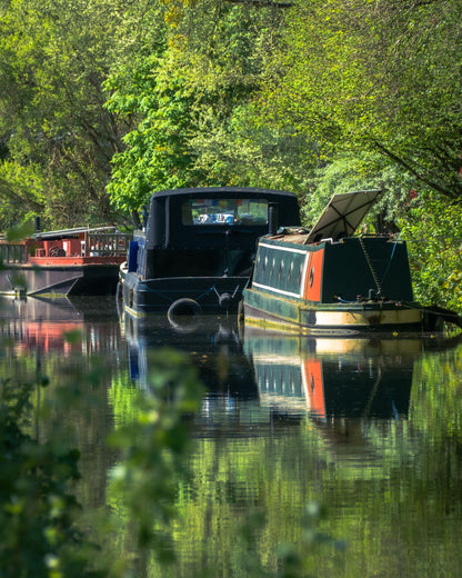 A converted narrowboat moored on a misty English river at dawn, evoking the Floating Spa barge on the Thames at Monkey Island Estate