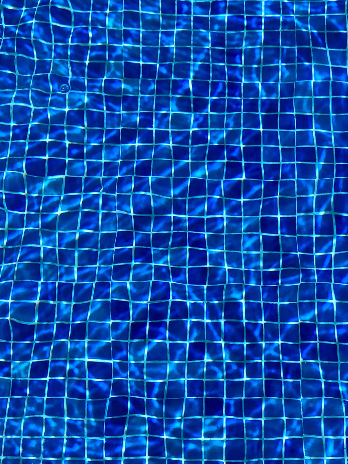 Shimmering blue mosaic tiles beneath the pool at Ritz Paris Club & Spa.