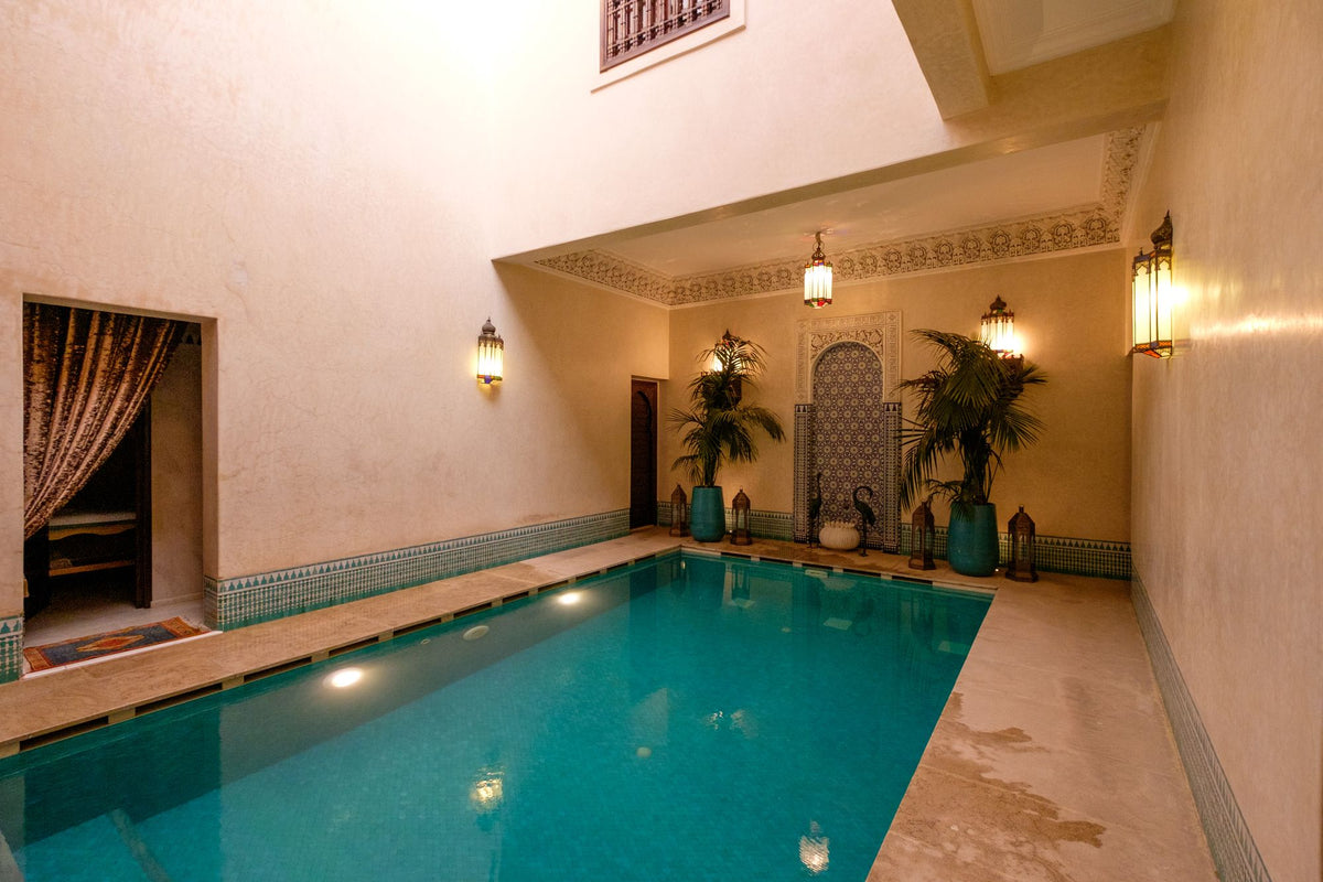 Indoor pool within a traditional riad, with arched stonework and warm light