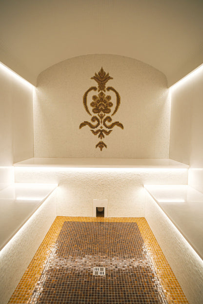 A mosaic lined steam room glowing gold, evocative of a citrine steam room