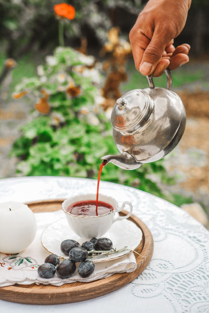 Hand pouring tea into a cup in a walled garden at The Bath House Spa, Royal Crescent