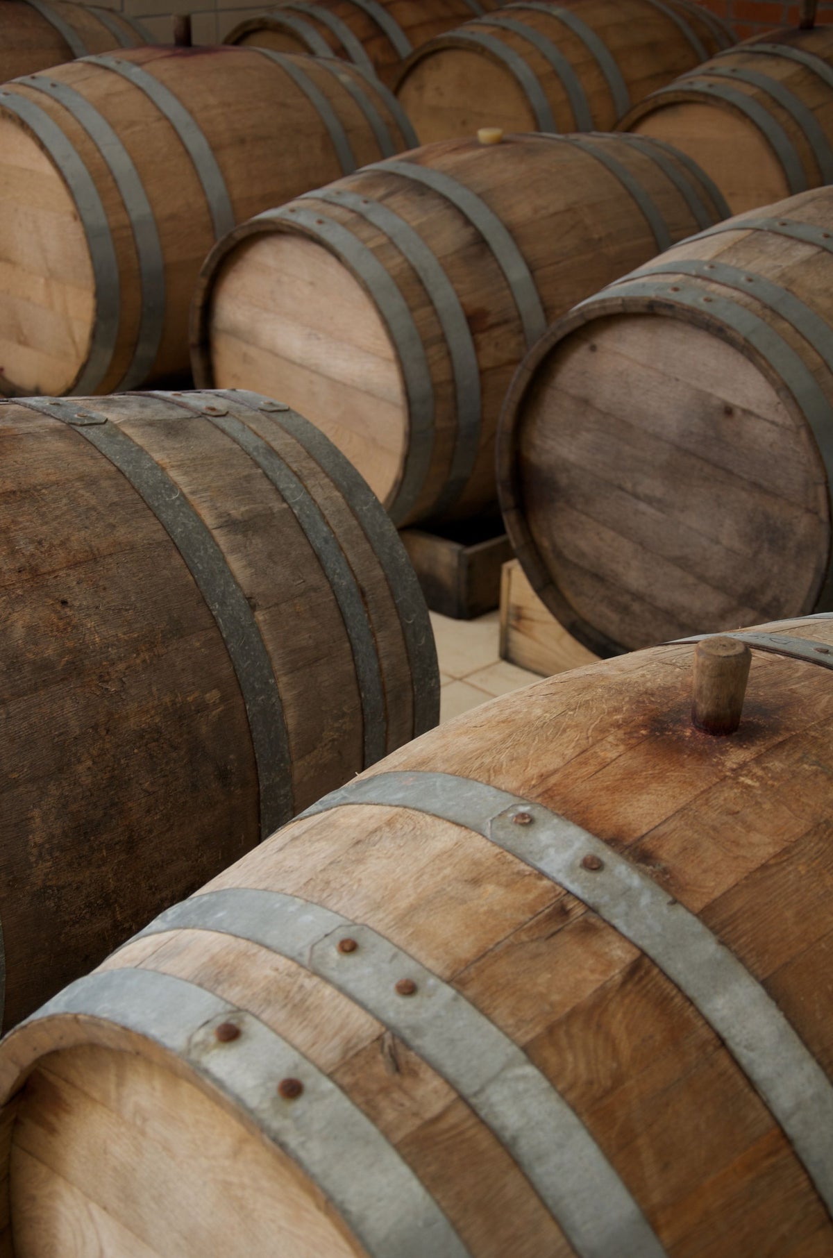 Stacked oak wine barrels with metal hoops, evoking the vinotherapy treatments at Hotel Marques de Riscal