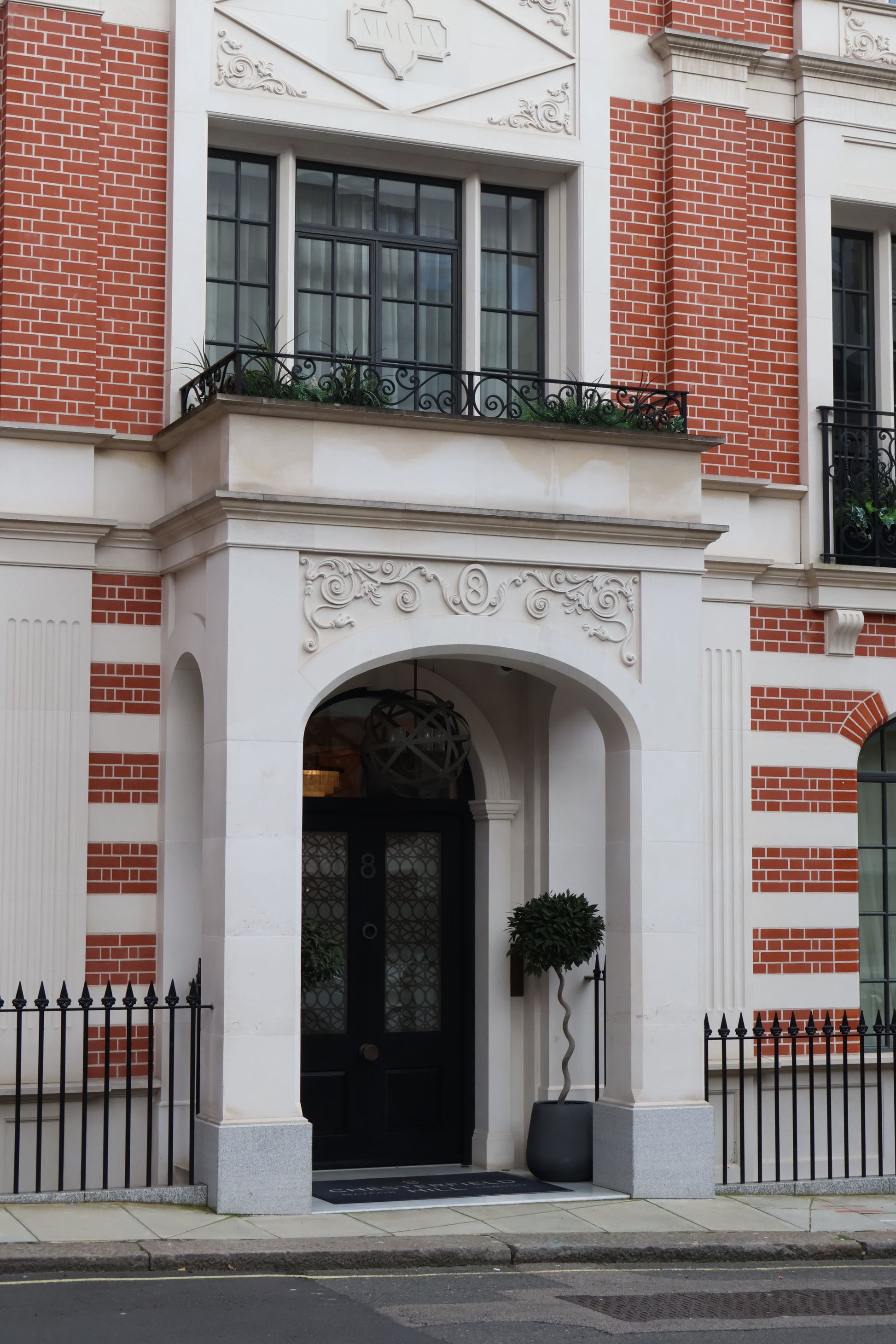 A red brick and stone facade with an arched doorway in Mayfair, London, near Dover Street