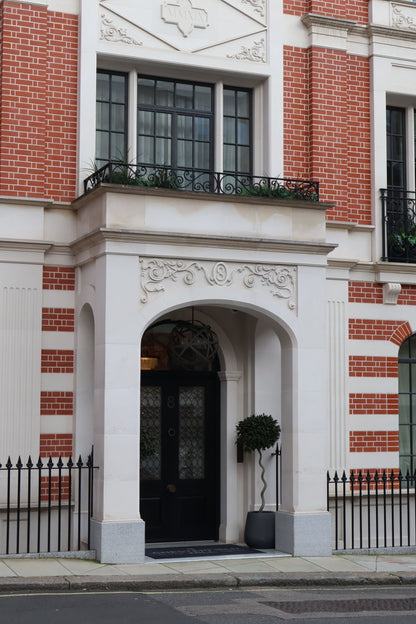 A red brick and stone facade with an arched doorway in Mayfair, London, near Dover Street