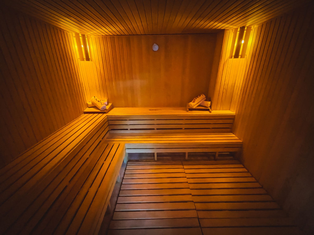 A softly lit wooden sauna, its slatted benches glowing under warm light.