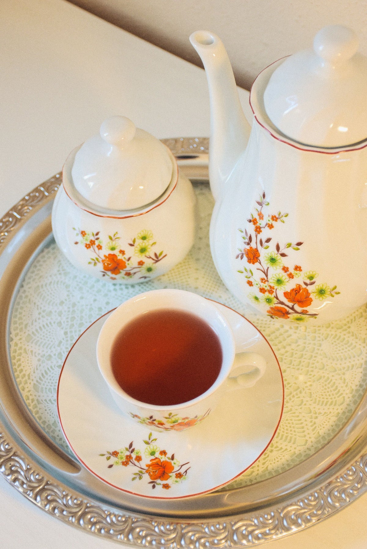 An elegant floral tea set on a silver tray, evoking the Hartwell Club Room complimentary tea service