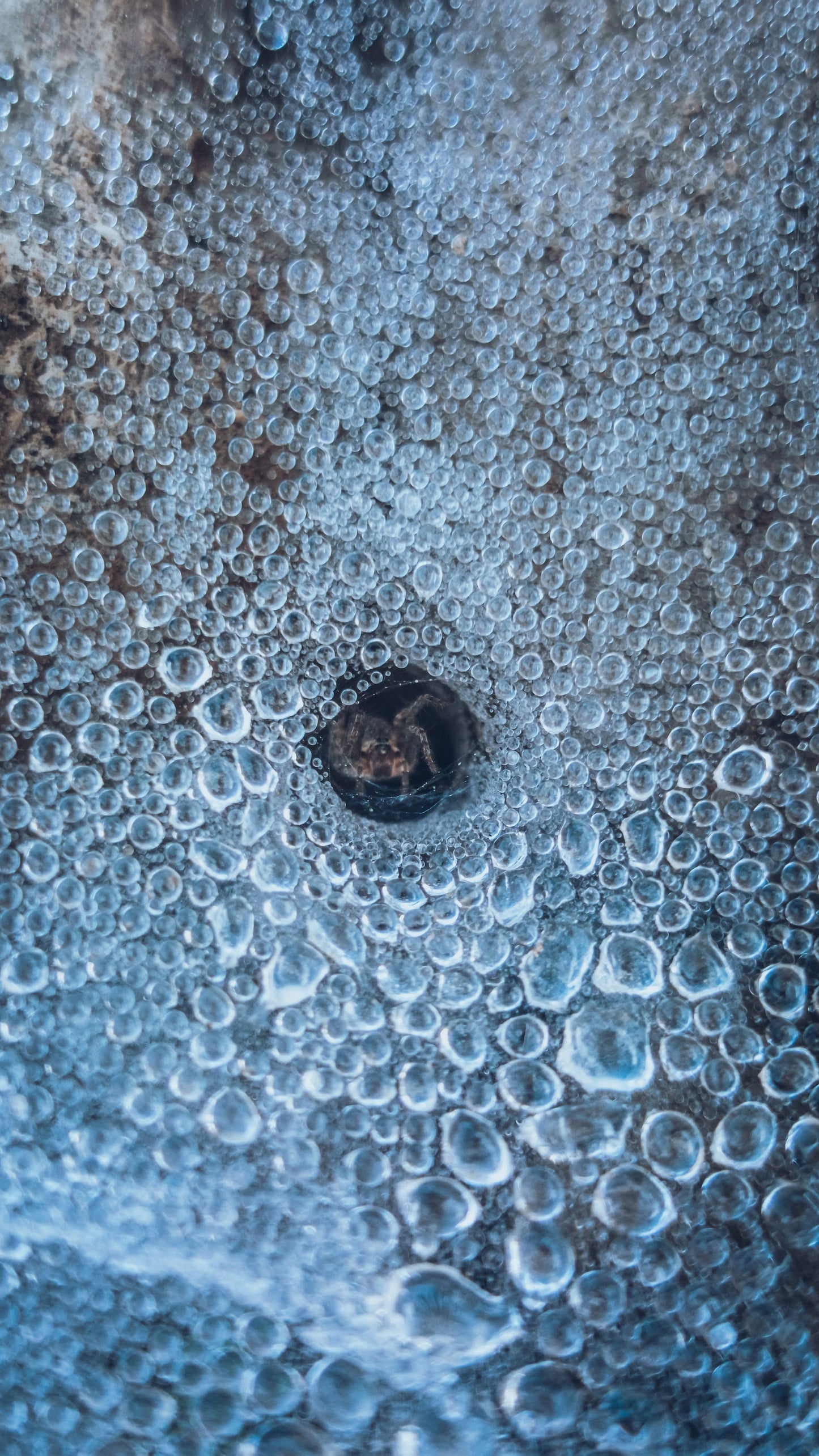 Air bubbles caught in blue ice, close up, standing for the ice fountain.