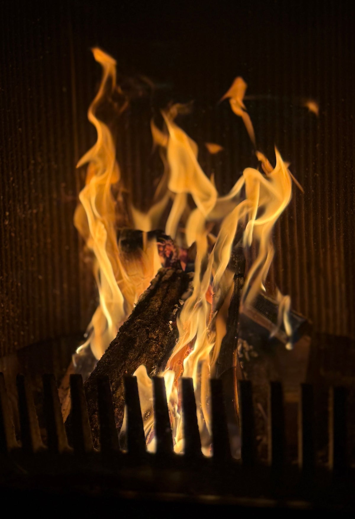 Flames burning in a stone fireplace, evoking the log fires at Brimstone Hotel