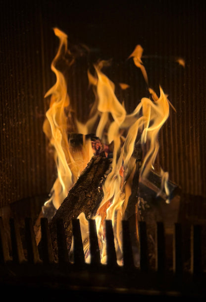 Flames burning in a stone fireplace, evoking the log fires at Brimstone Hotel