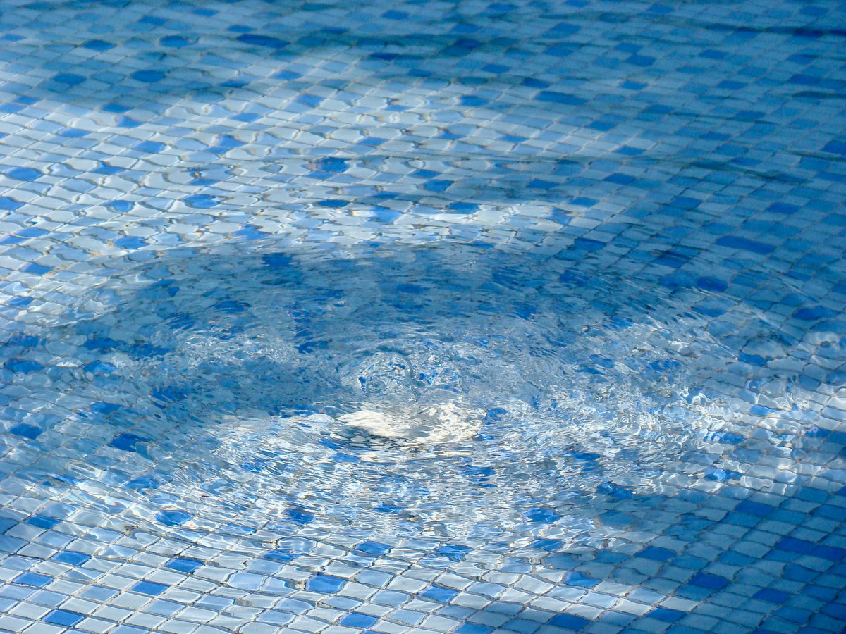 Bubbles rising through tiled pool water, evoking the bubble experiences in the relaxation pool