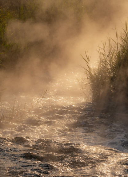 Steam rising from warm water into cold morning air