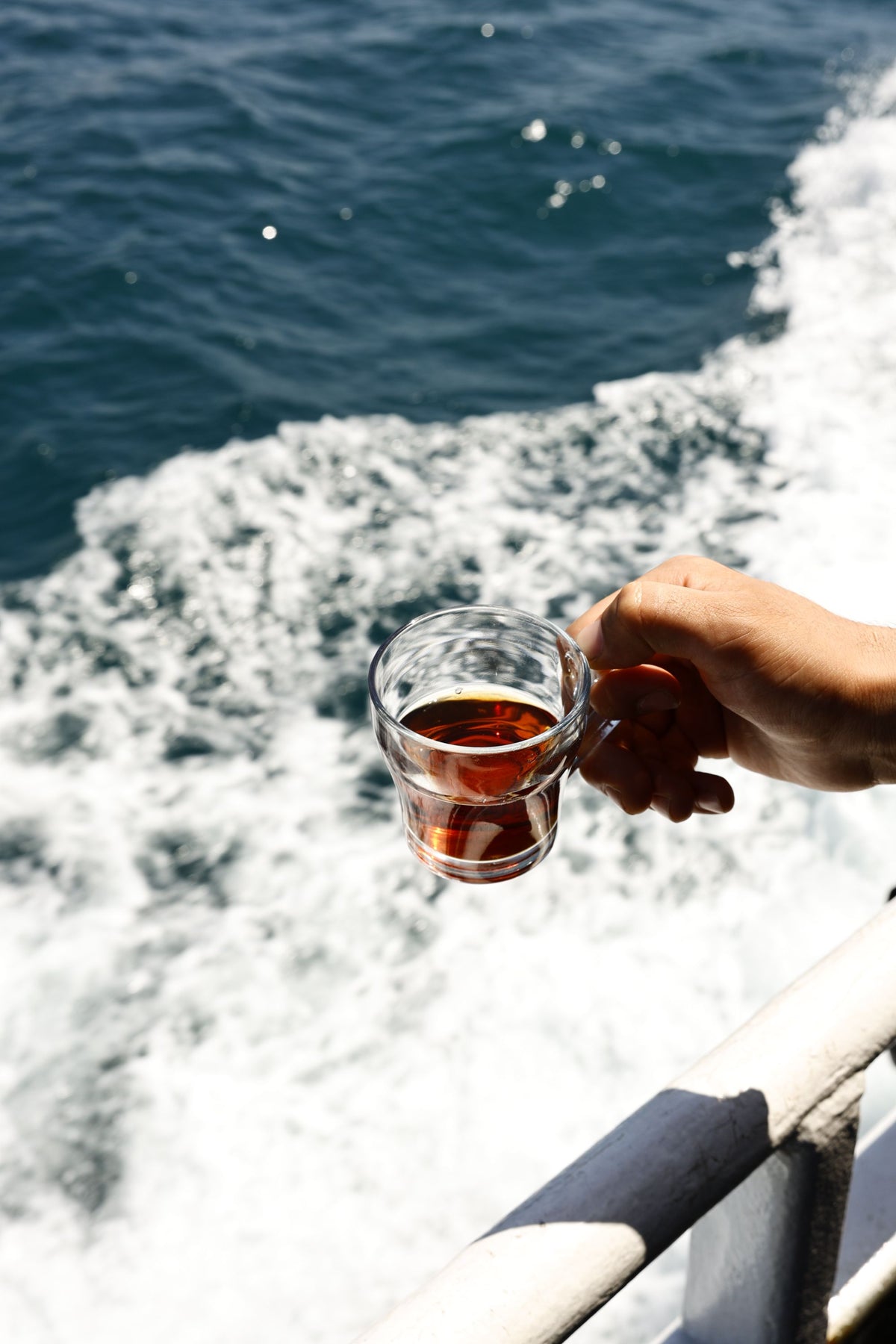 Hands holding a glass of warm tea against a frosted pane, evoking the quiet daily rhythm of a residential wellness programme