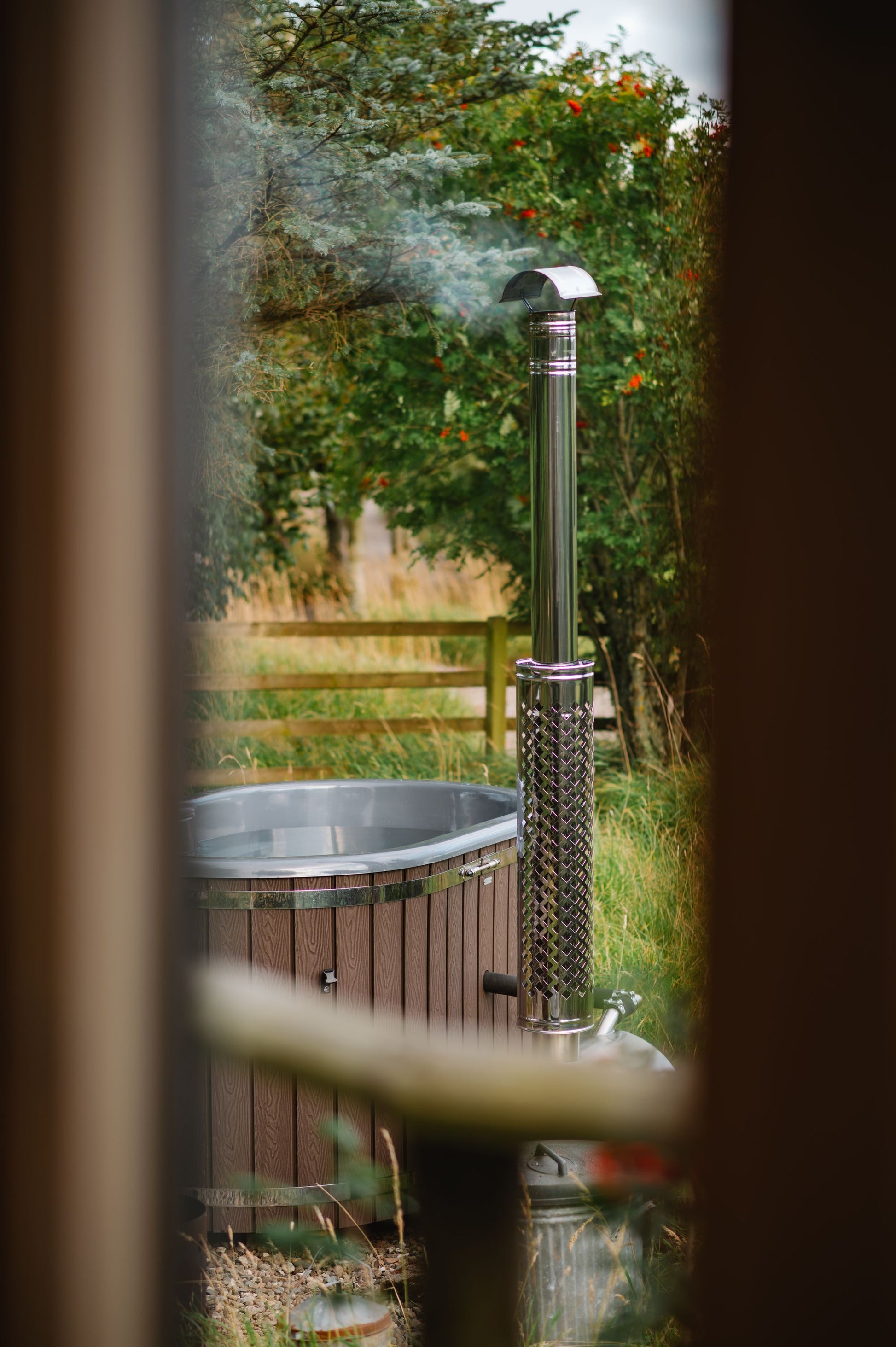 Steam rising from a wood fired hot tub tucked among garden trees, Galgorm Thermal Spa Village, Ballymena