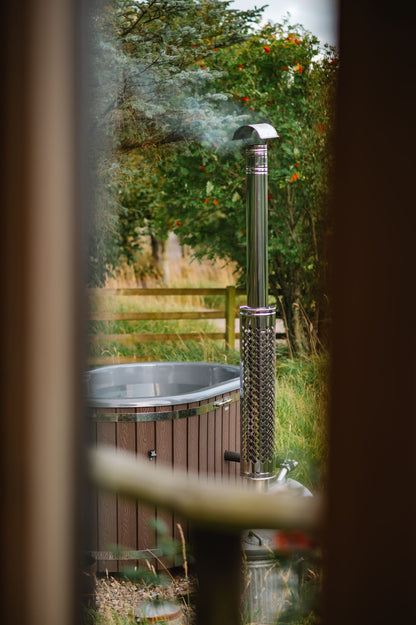 Steam rising from a wood fired hot tub tucked among garden trees, Galgorm Thermal Spa Village, Ballymena