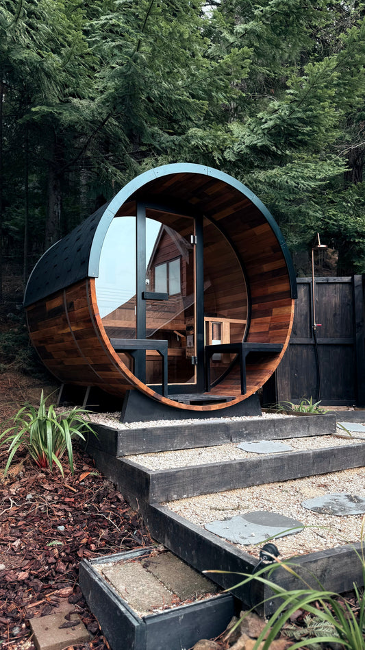 A timber sauna cabin with a round window on to the green outside, The Spa at Ellenborough Park, Cheltenham