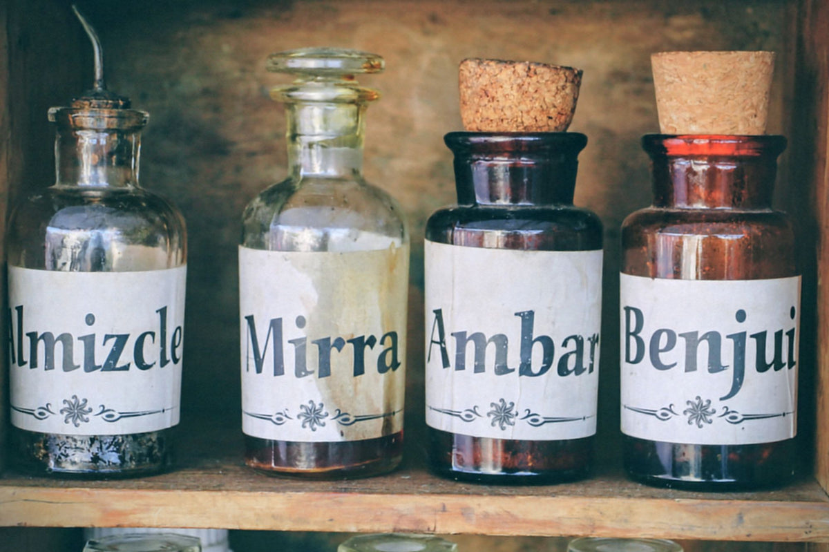 Vintage apothecary bottles on a wooden shelf, evoking the herbal oils cured for the Floating Spa's massages