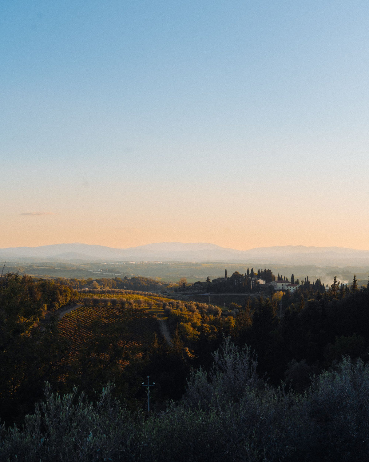 Soft golden light over the rolling Tuscan countryside at dusk