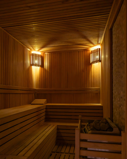 Warm wooden sauna interior with soft lamplight, part of a South Tyrol medical spa's thermal floor