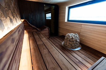 A sauna lined in warm timber with a window at the far end, standing for the windowed sauna and its Himalayan salt wall