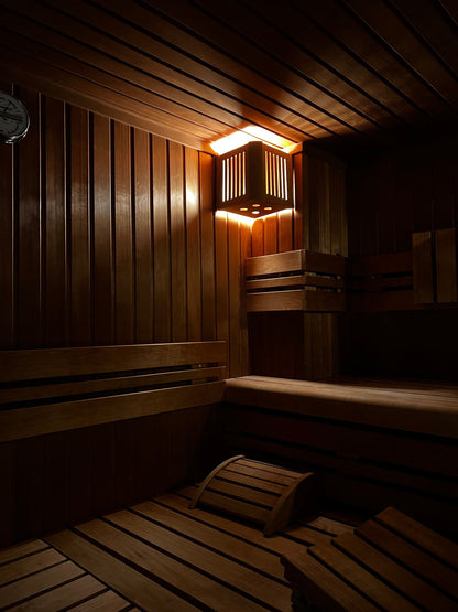 Warm lamplight across the timber boards of a sauna, one of the two single sex thermal suites at The Peninsula Spa