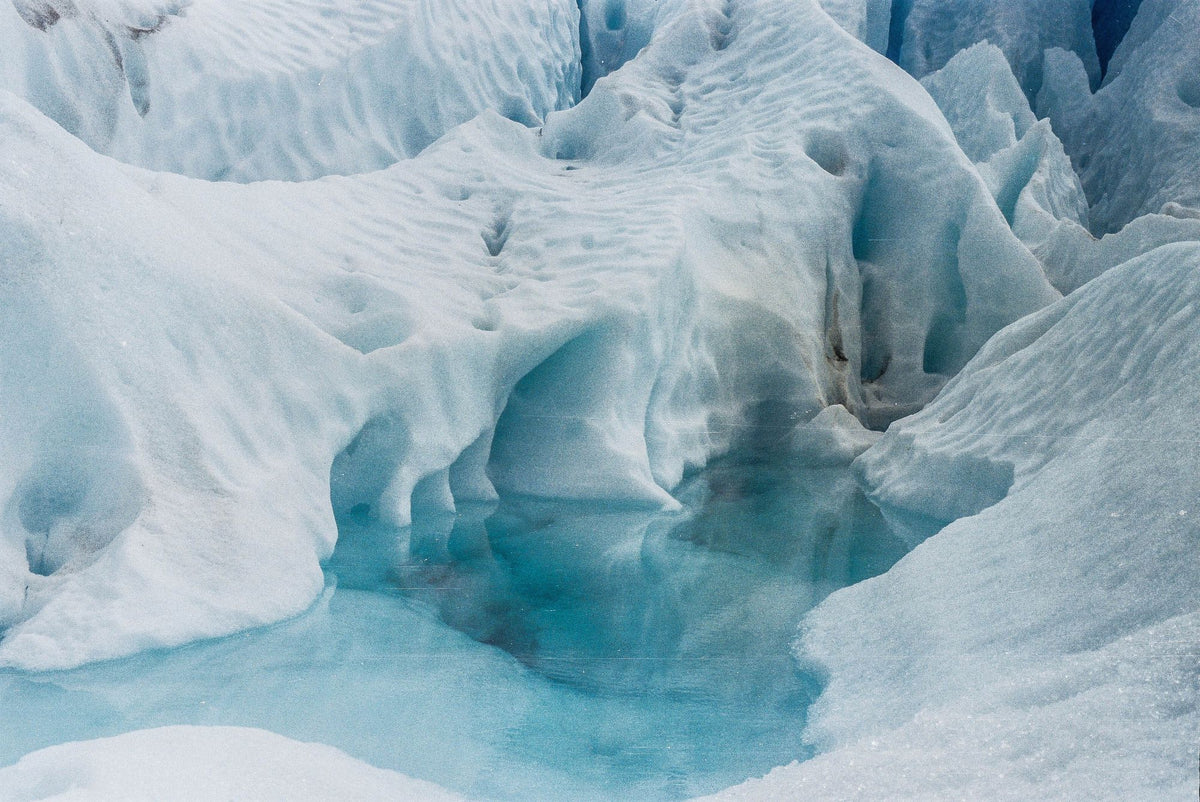 Blue glacial ice formations with a meltwater pool in the Alps above Évian