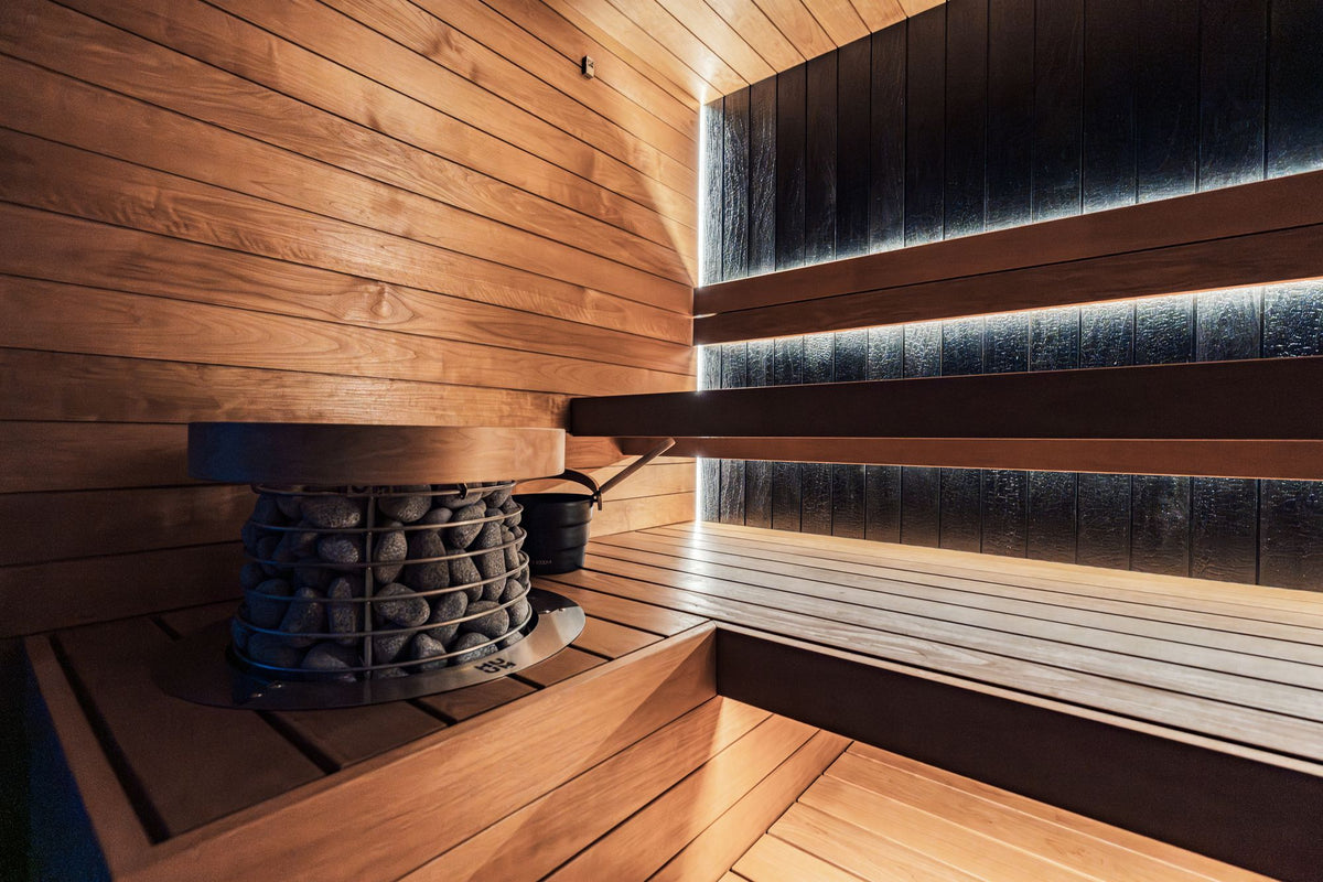 A modern indoor sauna with wooden panels and an electric heater