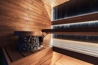 A modern indoor sauna with wooden panels and an electric heater