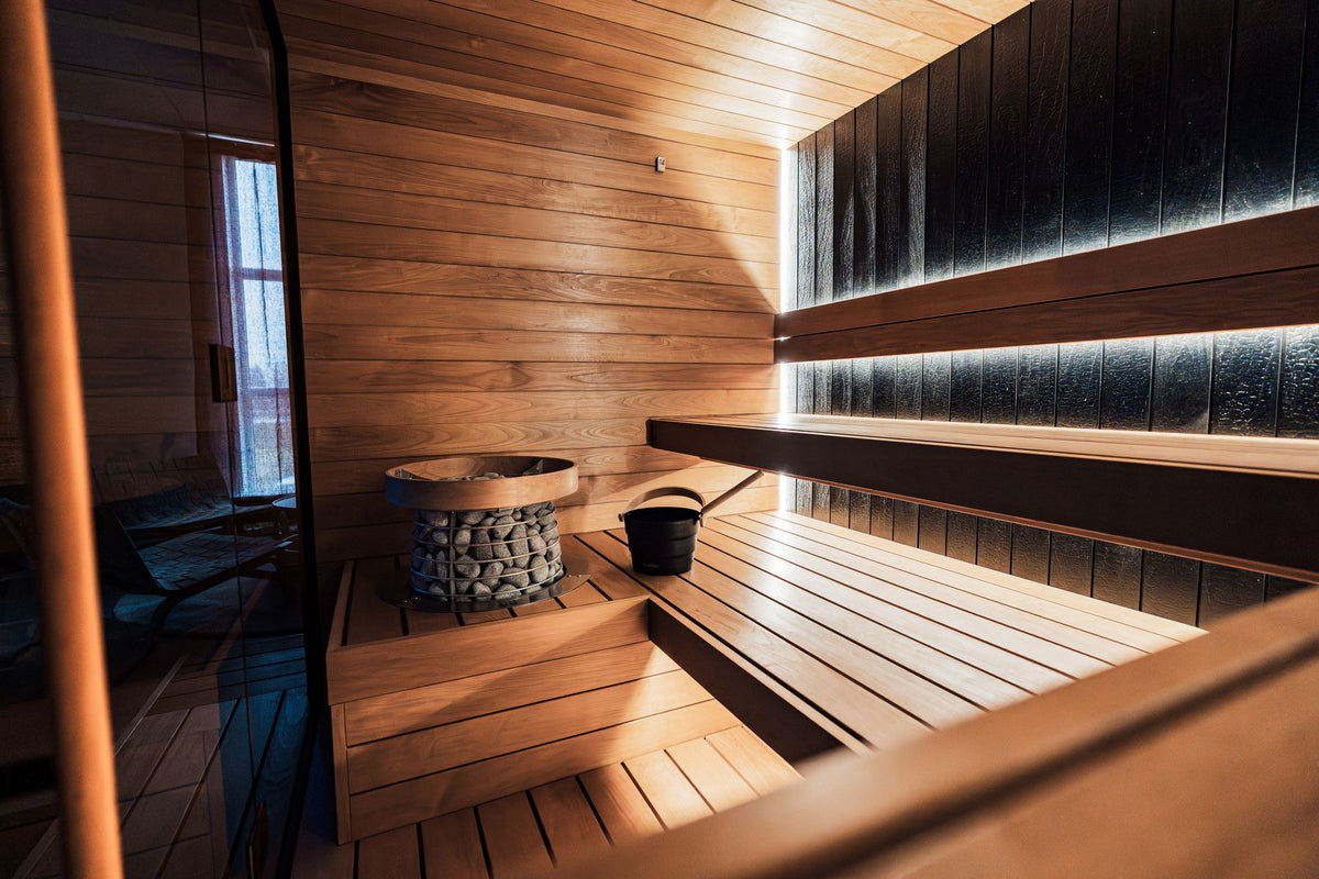 A dark wood sauna interior with heated stones, part of the thermal circuit at Spa La Mer.