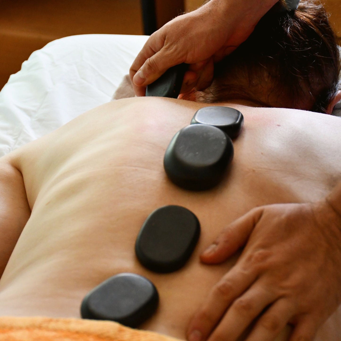 Warm stones placed along a guest's back during a hot stone massage