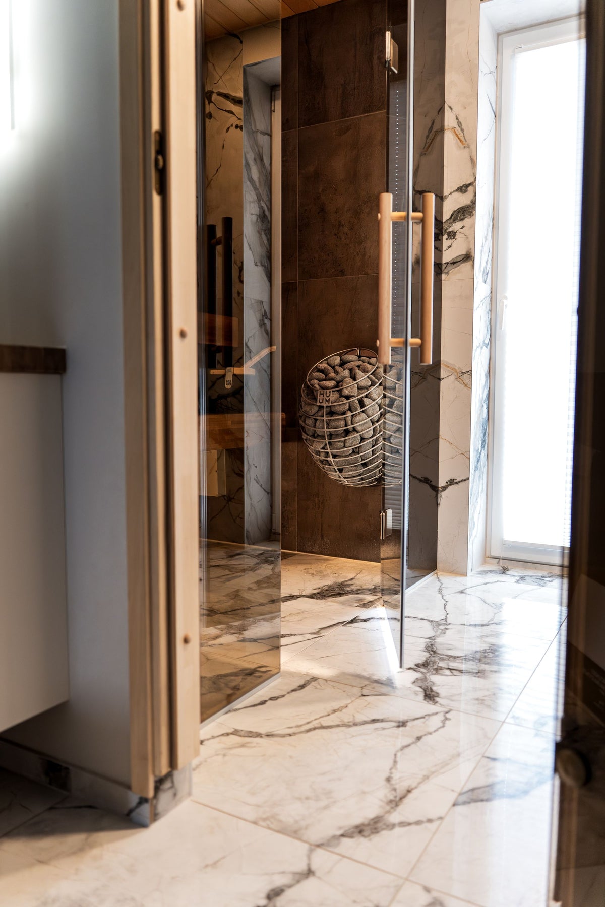 A marble lined sauna with warm wood accents