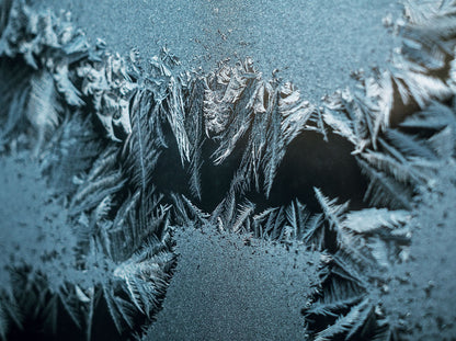Intricate frost patterns on glass, evoking the cold plunge after the warm bath