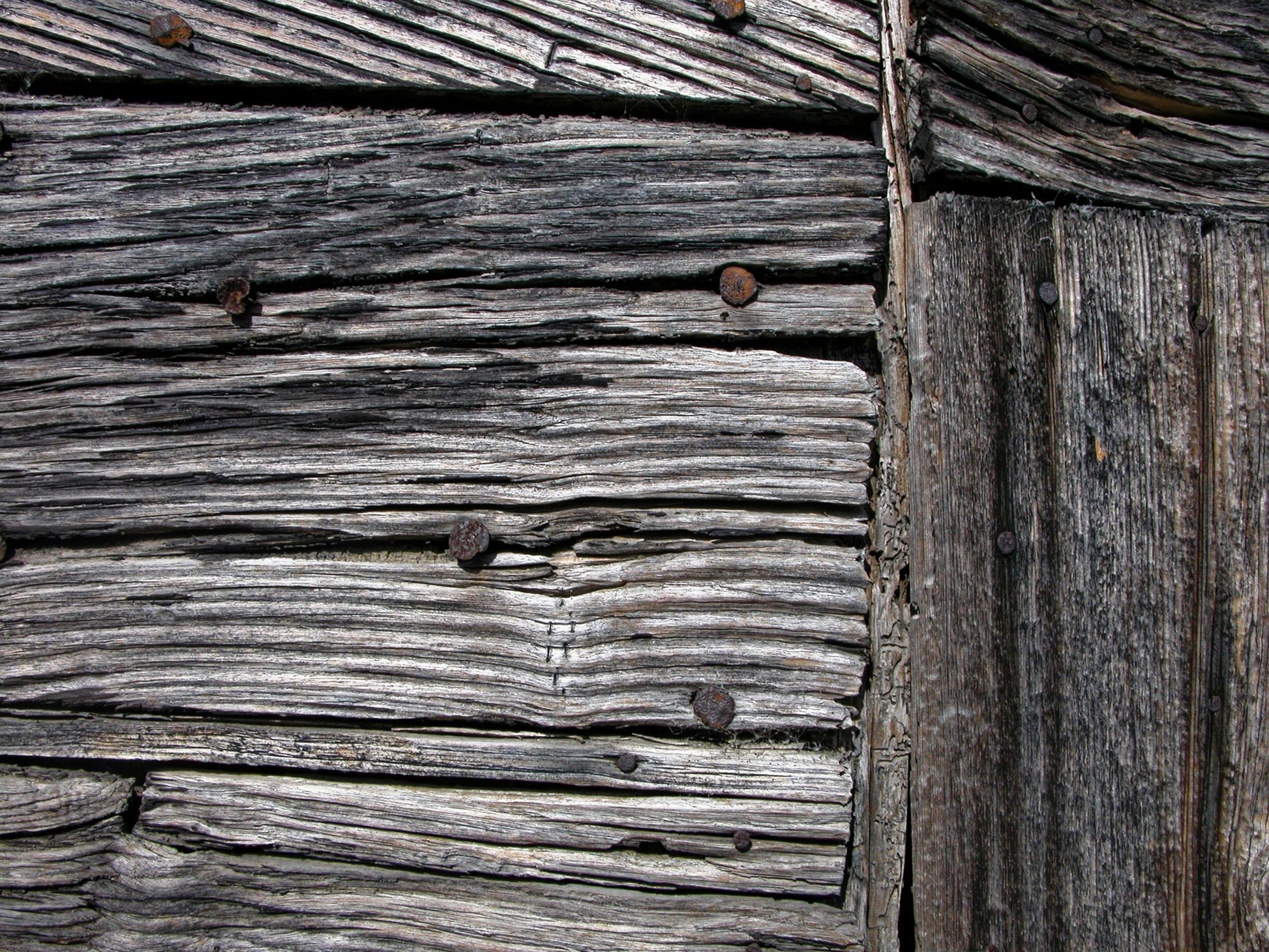 Close detail of weathered timber, evoking the estate original farm buildings