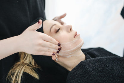A facial cleanse in soft light against dark towels, Surrenne at The Emory