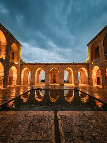 Warm evening light over a historic stone courtyard evoking The Cross Bath in Bath