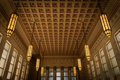 A grand Art Deco hall with coffered gold ceiling and pendant lamps