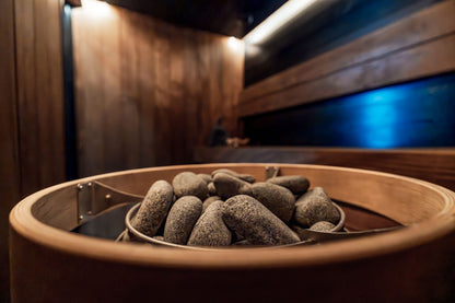 A dark timbered sauna interior with hot stones and low blue light, Galgorm Thermal Spa Village, Ballymena
