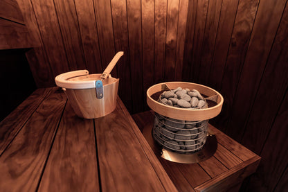 A warmly lit wooden sauna interior with tiered benches.