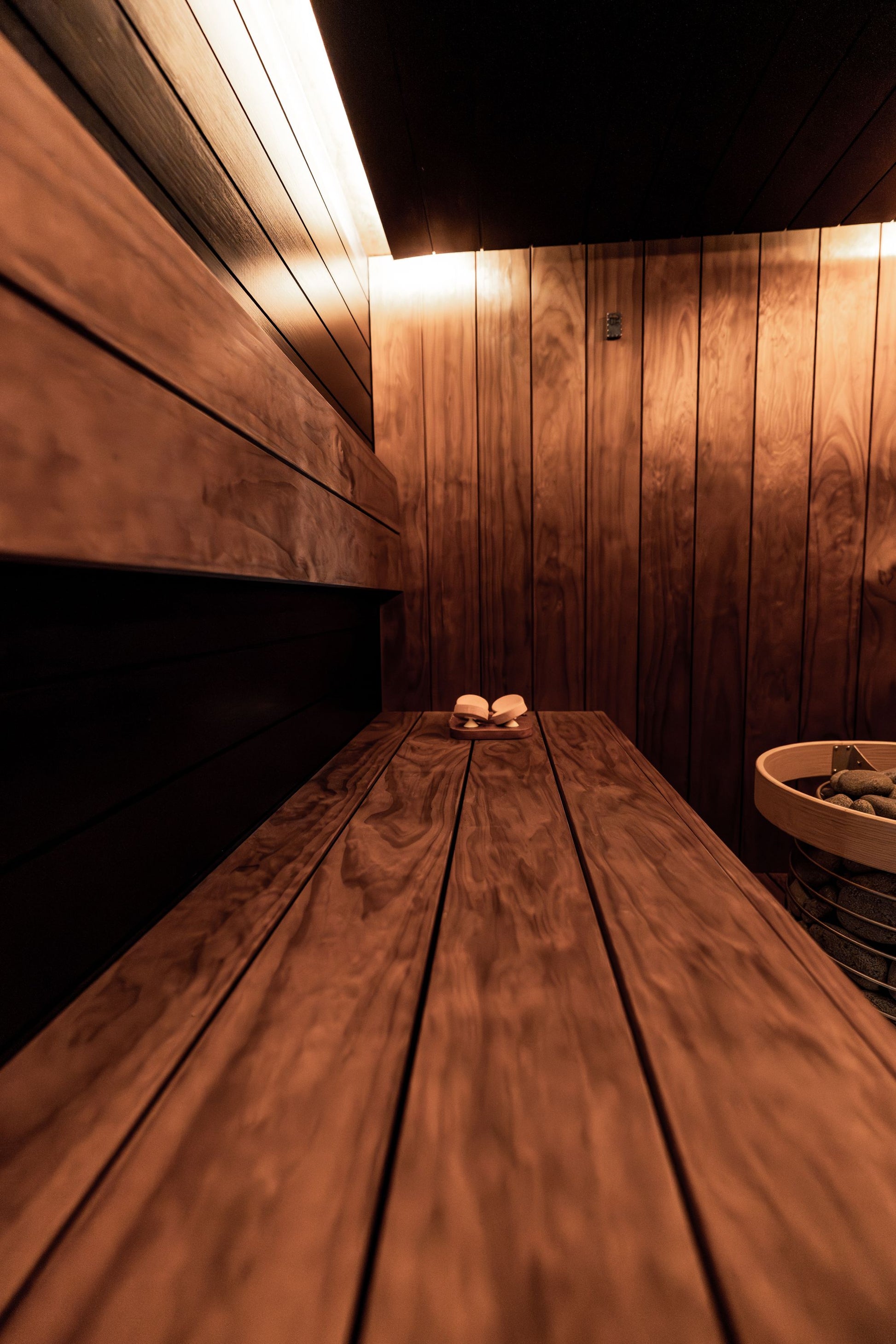 A warm wood lined sauna interior with soft low lighting