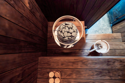 A Nordic sauna interior with a wood fired heater and stones seen from above